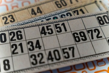 Bingo cards with numbers and grid layout placed on a wooden table
