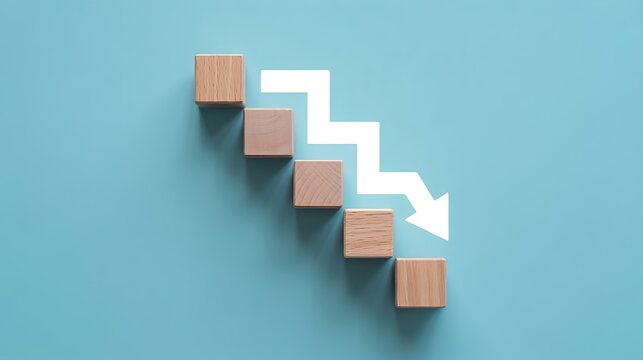 Five wooden blocks arranged in a descending staircase pattern with a white zigzag arrow pointing downwards, symbolizing business decline, financial crisis