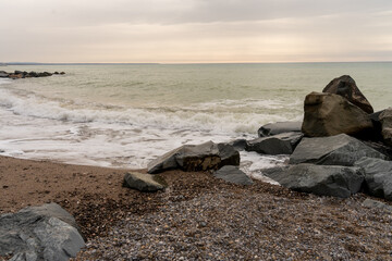 Scenic coastal landscape featuring a rocky shoreline with large natural stones