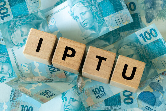  IPTU Brazil. An abbreviation for annual property tax. A financial and business concept. A symbol on wooden blocks, the Brazilian money, Real banknotes