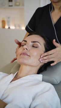 Woman receiving a relaxing facial massage in a spa setting.