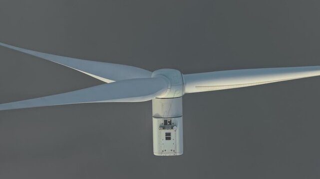 Offshore wind turbine generating clean renewable energy from wind power. The huge blades spin against a grey, foggy sky at ijsselmeer, netherlands