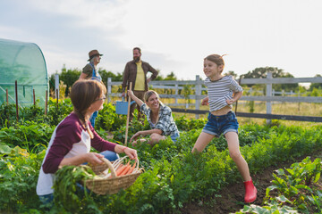 Naklejka premium Happy farmers or gardeners working outdoors at community farm.