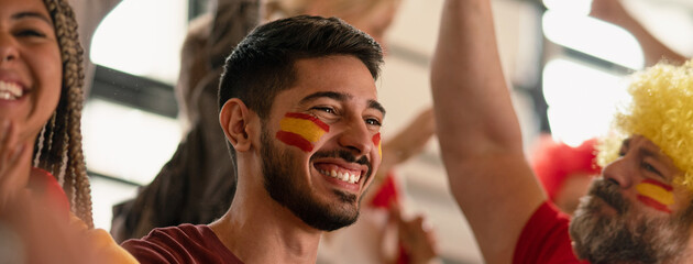 Excited football fans supproting spanish national team in live soccer match at stadium. © Halfpoint