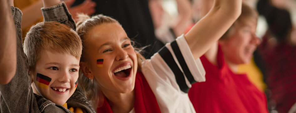 Young German football fans celebrating their team's victory at stadium.