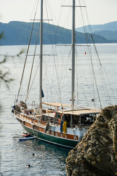 Two-Masted Wooden Gulet Anchored Near Coastal Rocks in Montenegro