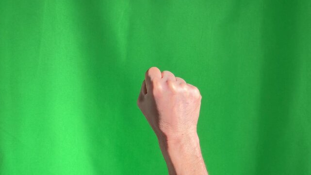 Rising fist up, hand on chroma key green background.