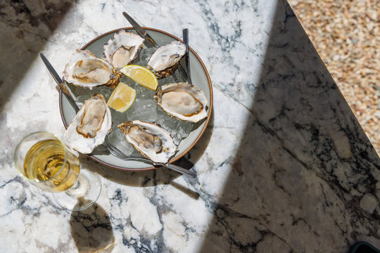 Fresh oysters on ice with champagne in sunlight