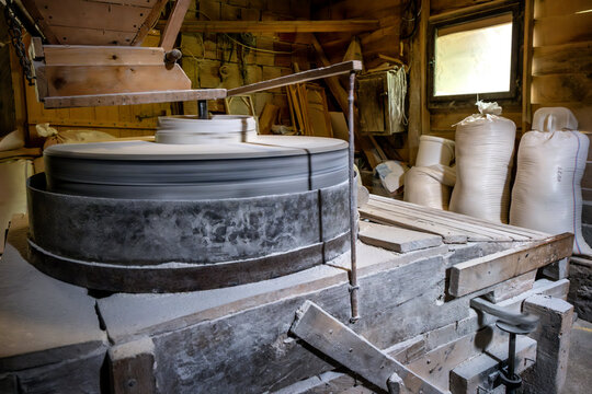Inside the old wooden flour grinding mill. Interior of retro wooden watermill with old equipment for grinding or milling grain into flour