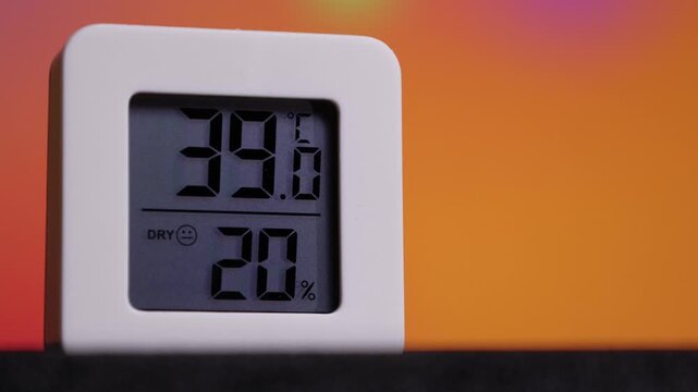 Temperature and humidity reading on a device showing 38.6 degrees and 20 percent in a room at night