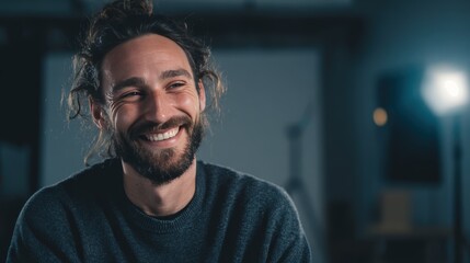 Obraz premium Smiling man with beard in softly lit minimalist studio with blurred background