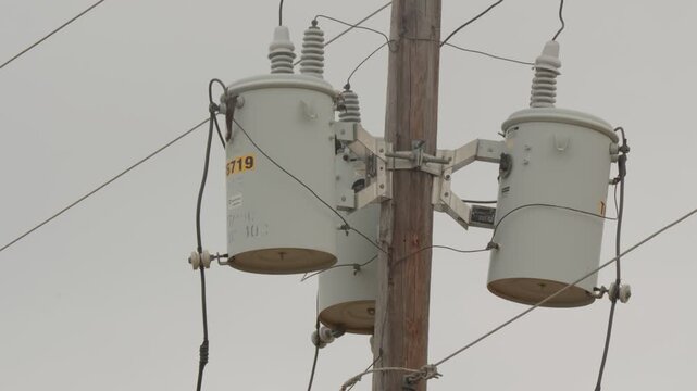 Utility power pole with transformers, insulators, cross-arm, wires