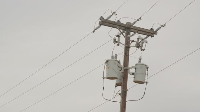 Utility power pole with transformers, insulators, cross-arm, wires