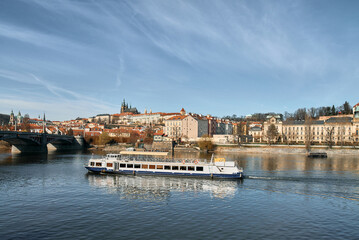 Fototapeta premium Vltava river cruise boat passes Prague Castle and St Vitus Cathedral skyline