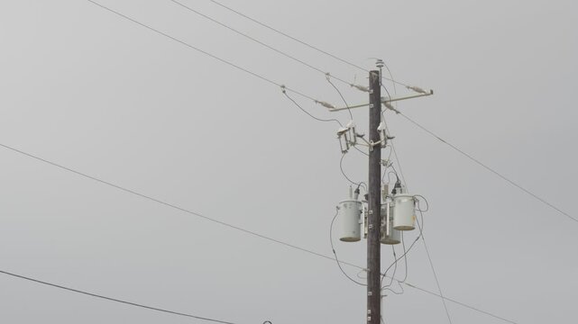 Utility power pole with transformers, insulators, cross-arm, wires