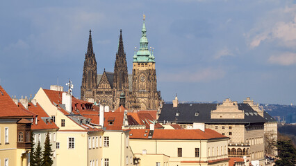 Obraz premium St Vitus Cathedral towers above red roof rooftops in Prague Castle district skyline