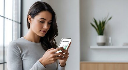 Young woman with dark hair holding a smartphone displaying a financial chart with upward trend focusing on stock market data for investment decisions in a bright modern home