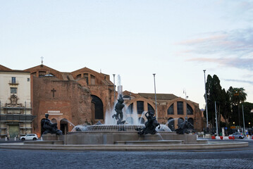 Obraz premium Piazza della Repubblica in Rome, Italy. In the center is the Fountain of the Naiads, and in the background stands the Basilica of Santa Maria degli Angeli e dei Martiri.
