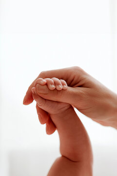 Mother holding newborn baby's hand &ndash; parenthood, love, protection and family bonding