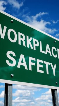 Green directional sign indicating workplace safety against a blue sky