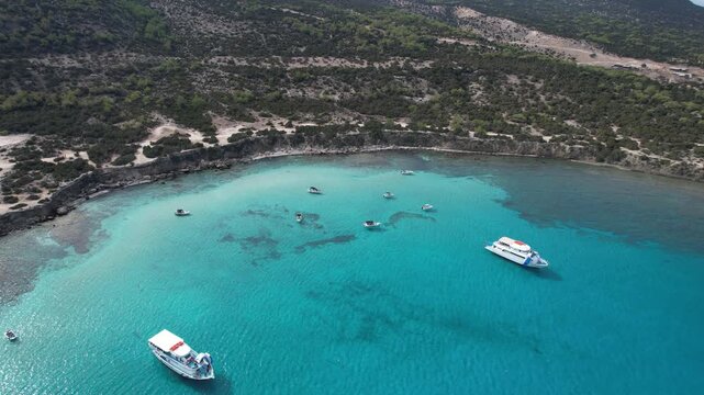 Drone aerial seascape of Akamas blue lagoon, cyprus, featuring tourist boats anchored in turquoise waters, surrounded by a wild coastline. Akamas peninsula travel destination paphos Cyprus.