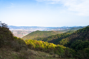 Fototapeta premium Lush green landscape with small rolling mountains, showcasing serene natural scenery, fresh grass, and peaceful countryside atmosphere.