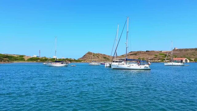 Sailboats anchored in blue bay of Menorca on sunny summer day