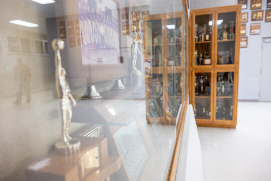 Trophies and awards displayed in a school hallway showcasing student achievements and school pride during the daytime