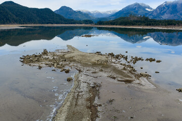 Scenic Low-Water Lake With Exposed Tree Stumps And Mountain Reflections, Peaceful Landscape In BC, Canada