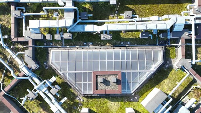 Modern energy-efficient house rooftop showcasing integrated utilities and pipes, with a gradual camera zoom out revealing the innovative design and sustainable features of the structure