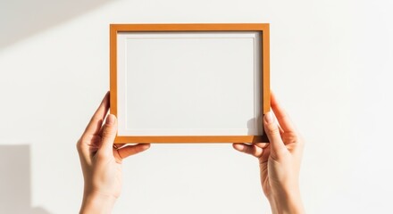 Hands holding wooden picture frame against white backdrop with copy space