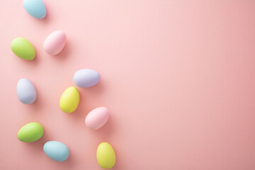 Pastel Easter eggs scattered on pink background. Minimalist spring holiday concept with copy space.