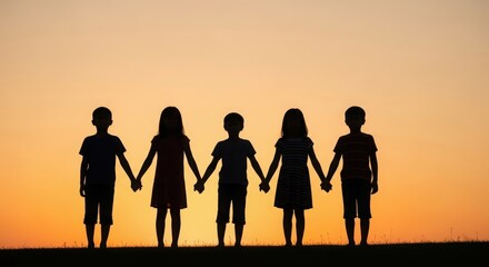 Fototapeta premium Silhouettes of children holding hands at sunset