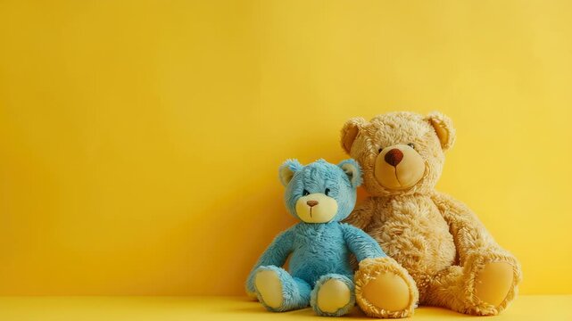 Two bears sitting against a bright yellow backdrop