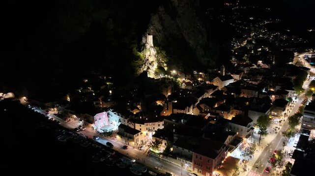 Night view of Mirabela fortress rising above historic Omis town in Dalmatia, Croatia.