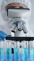 Scientific researcher wearing protective gear adjusting microscope, analyzing lab samples with precision in sterile research environment. Medicine, healthcare and science concept