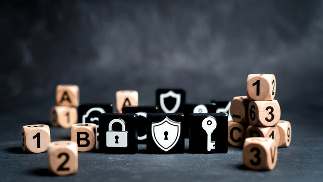 Black and wooden blocks with security symbols and alphanumeric characters on a dark surface.