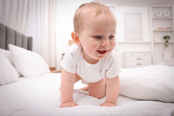 Fototapeta premium Cute little baby sitting on bed at home