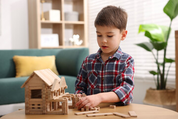Little boy playing with educational toy at wooden table indoors © New Africa