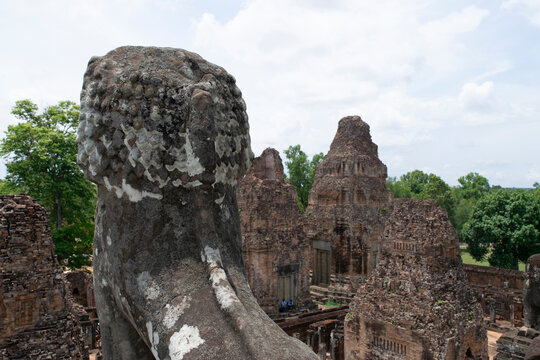 Stone lion statue overlooking ancient pre rup temple ruins