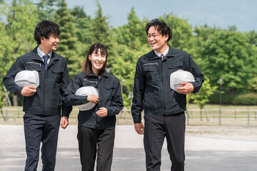Male and female workers in work clothes walking at the work site (construction industry, transportation industry, civil engineering industry, general contractor)