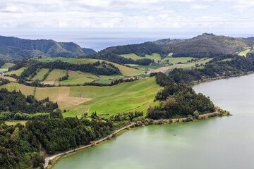 View from Pico do Ferro Viewpoint near Furnas. The Atlantic Ocean stretches out in the distance with Furnas Lake in the foreground. Sao Miguel in the Azores, Portugal. © Eugene Ga