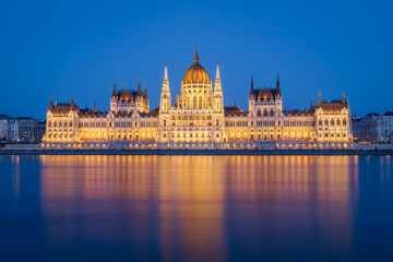 Fototapeta premium The Budapest Parliament building at nightfall on the Danube river bank