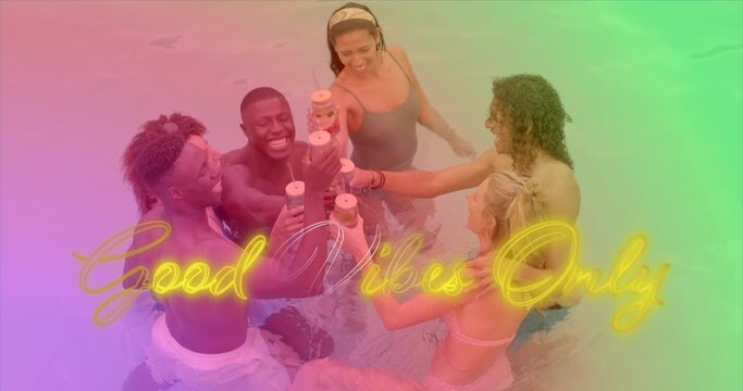 Clinking plastic cups, six adults leaning in waist-deep pool, in swimwear and neon Good Vibes Only