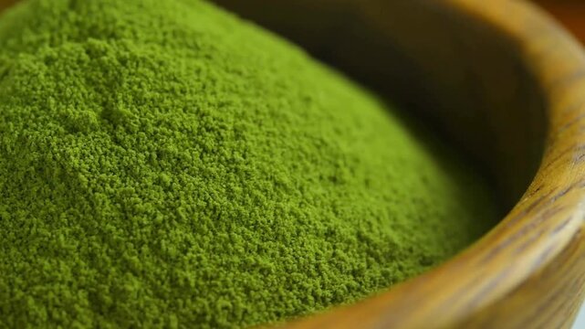 Organic Green Matcha Tea powder in wood bowl.