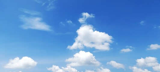 Obraz premium Bright summer day with clear blue sky and a few fluffy white clouds. Panoramic natural background of beautiful blue sky and clouds.