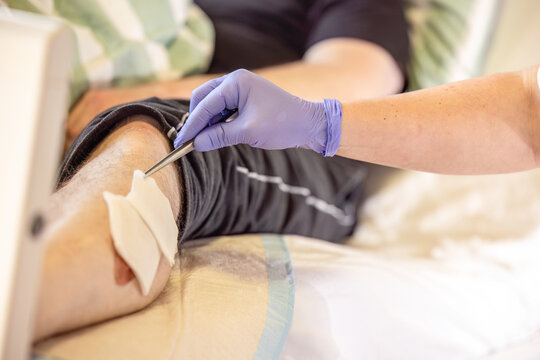 Instructor showing correct wound disinfection method with sterile gauze and forceps during nursing education