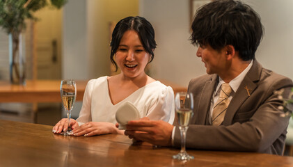A man makes a surprise proposal at a bar counter to a surprised woman