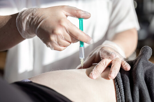 Close up of nurse administering intramuscular injection into gluteus medius of patient during medical treatment
