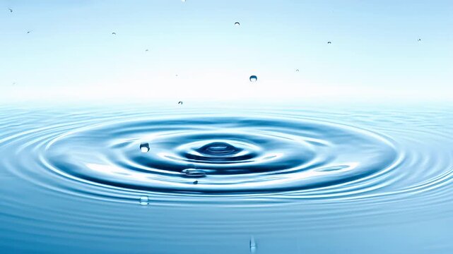 Therapy stress release treatment, health lifestyle. A highresolution water droplet suspended in midair, surrounded by ripples on the surface of the water. The droplet is a vivid blue.